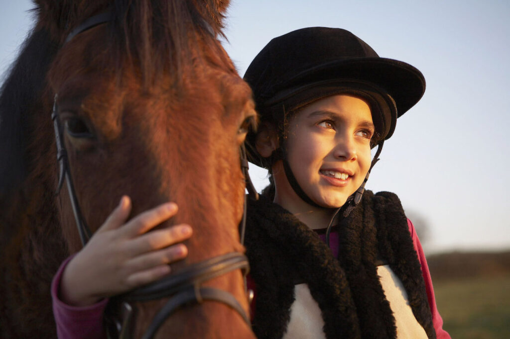 Una bambina abbraccia il suo cavallo.