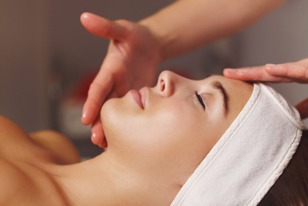 Una donna viene massaggiata sul viso